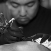 The Golden Needle Tattoo Studio, Phuket Town, Thailand. Tattoo artist Mee goes to work